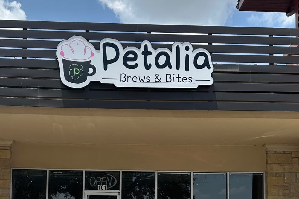 a sign near the top of a building that reads petalia brews & bites