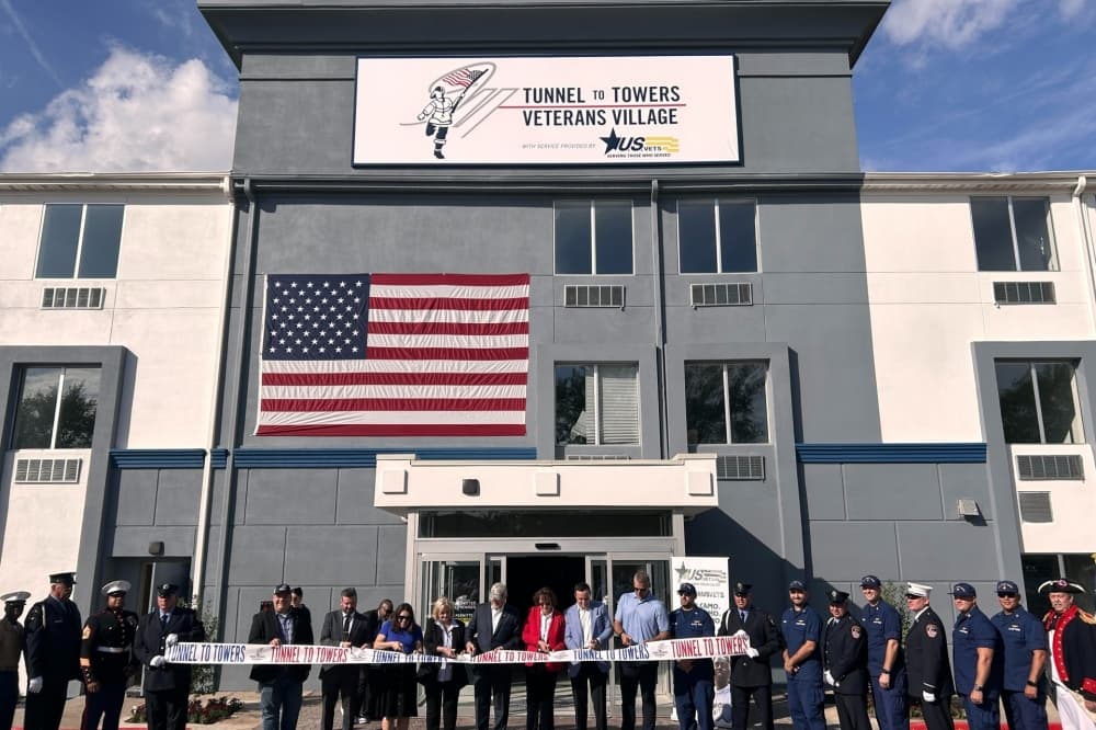 Tunnel to Towers Foundation representatives and first responders cut the ribbon by the entrance to the 161-room Veterans Village. (Shaheryar Khan/Community Impact)