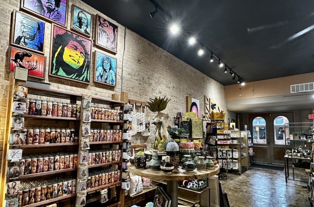 A wall of the store is covered with unique candles and colorful artwork.