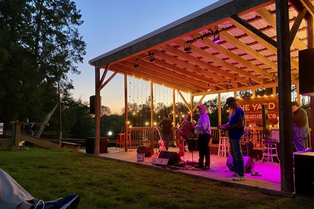 A man speaks on an outdoor stage.