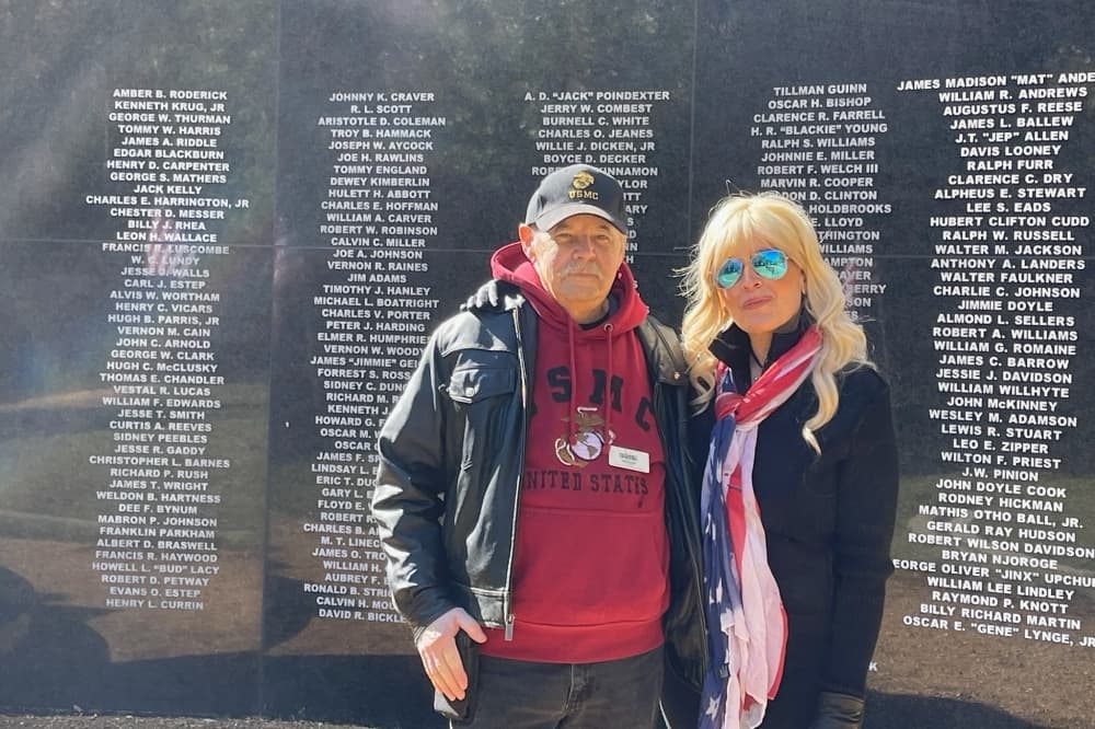 R.D. Foster and Trina Foster standing in front of the veterans memorial