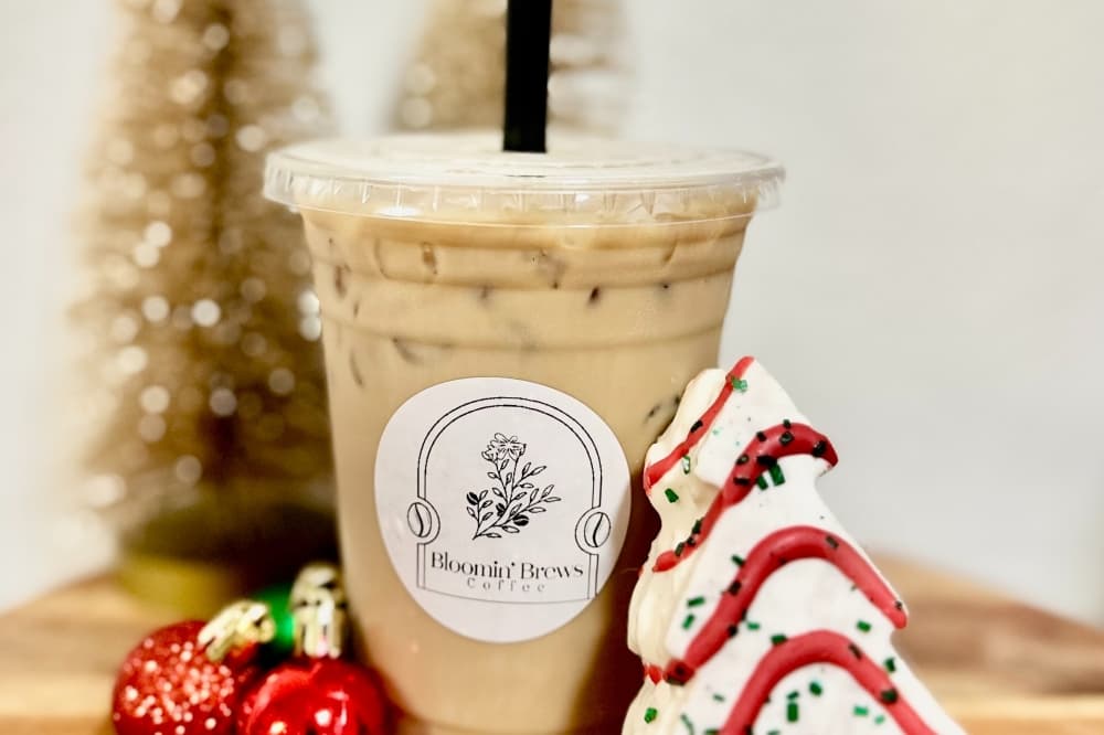 An iced coffee next to mini plastic ornaments and a Lil Debbie Christmas treat