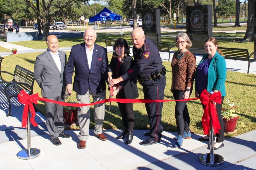 A photo of local officials at a ribbon-cutting ceremony for the Veterans War Memorial at Collins Park