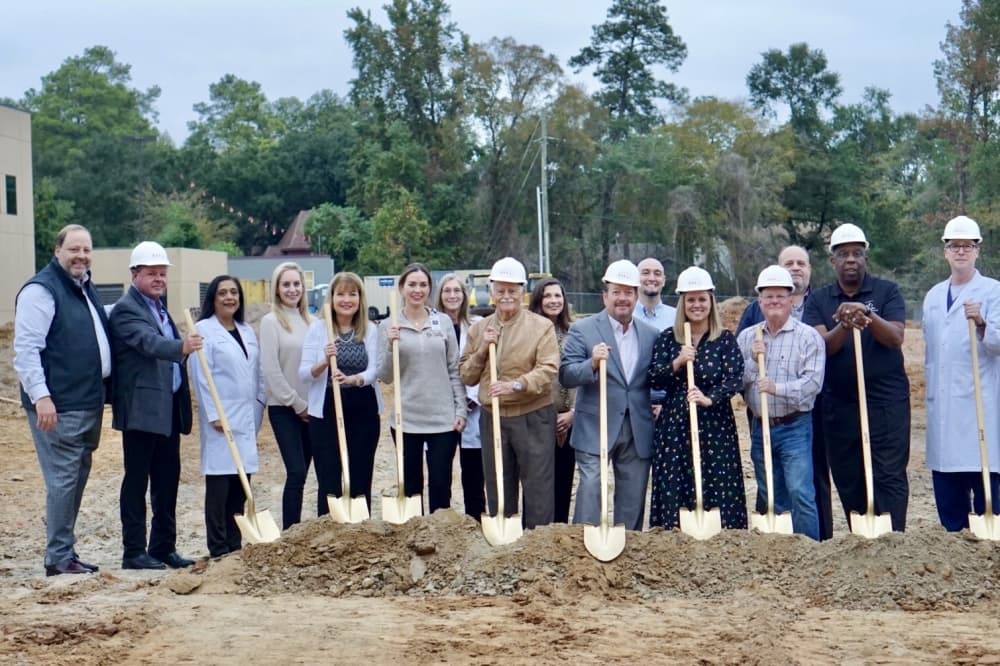 board members and administration from Lone Star Family Health hold shovels into the dirt
