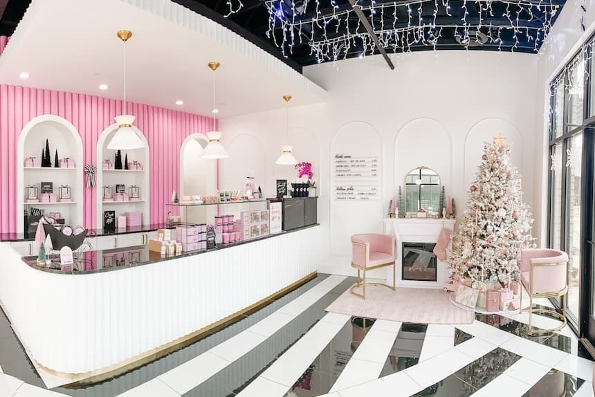The pink cafe is on the left with a soft-pink colored holiday vignette on the right with a Christmas tree and fireplace.