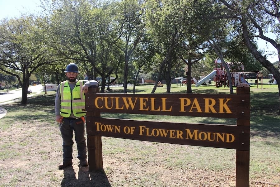Picture of a man standing next to a park sign.