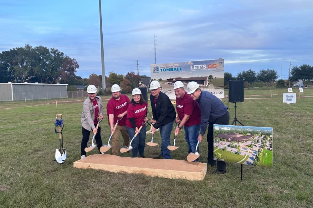 Members of First Baptist Church Tomball hold up dirt-filled shovels during a groundbreaking ceremony