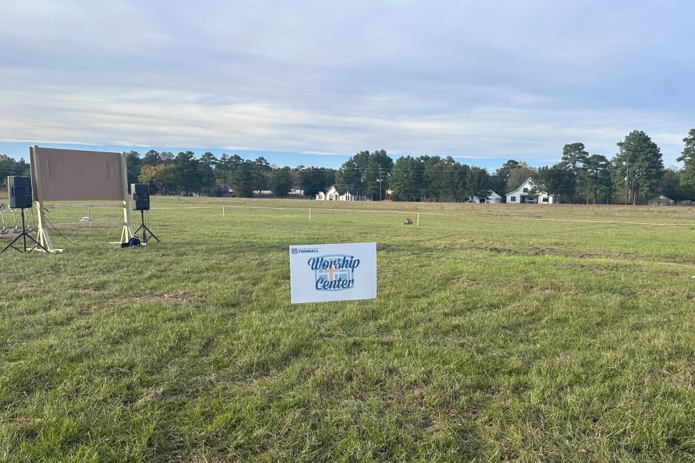 A sign that reads "Worship Center" placed in a field