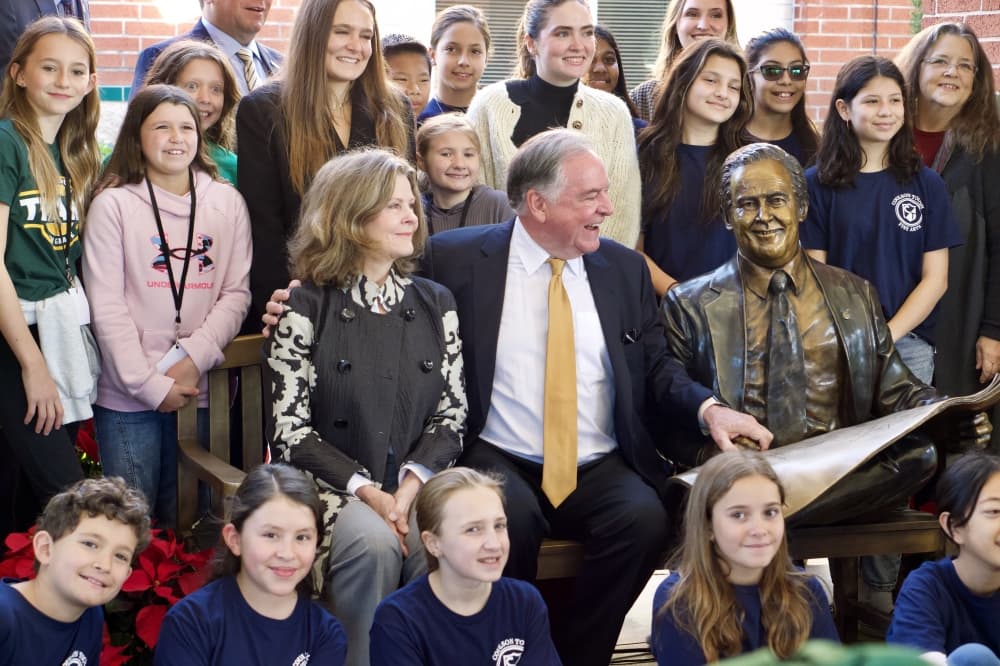 Bruce Tough, surrounded by family, friends and community members, take a photo surrounding the sculpture dedicated to the late Coulson Tough. 
