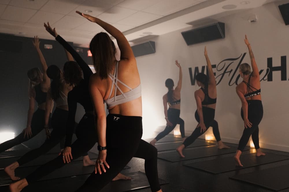 People are practicing yoga in a dimly lit room.