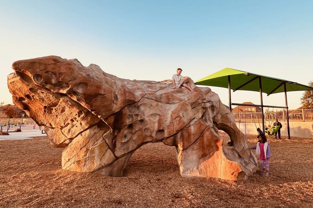 Kids playing on a boulder