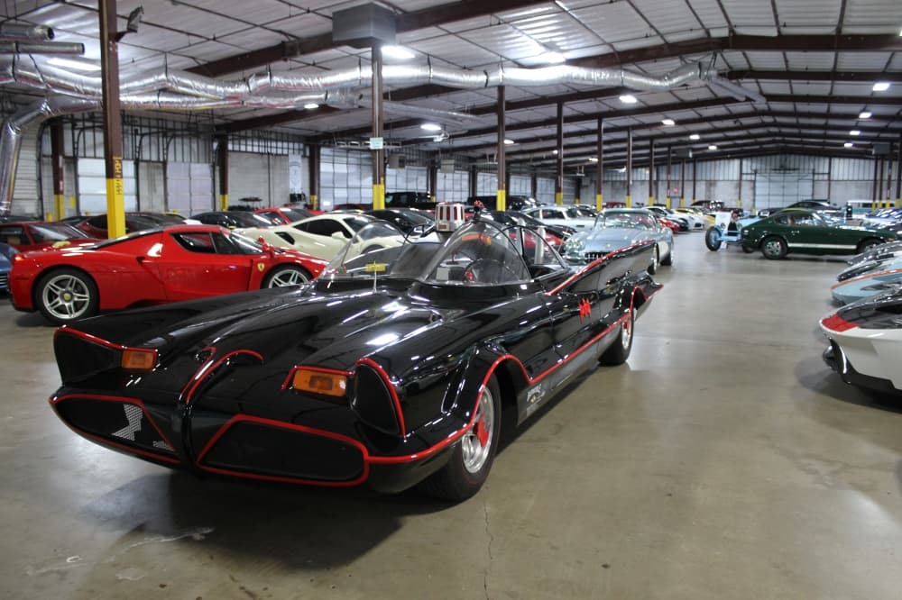 black and red batmobile surrounded by cars 