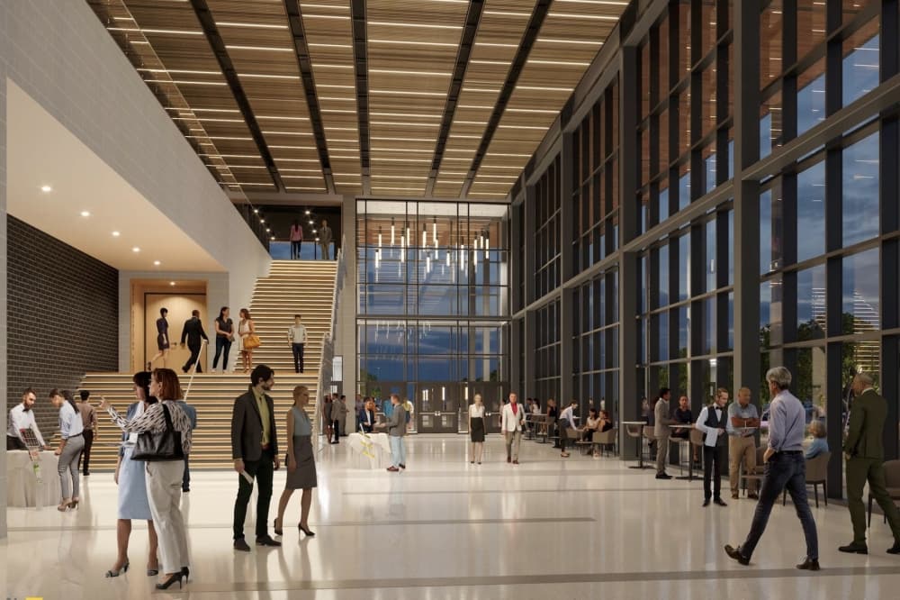 an interior of a performance hall lobby with open windows and a large staircase