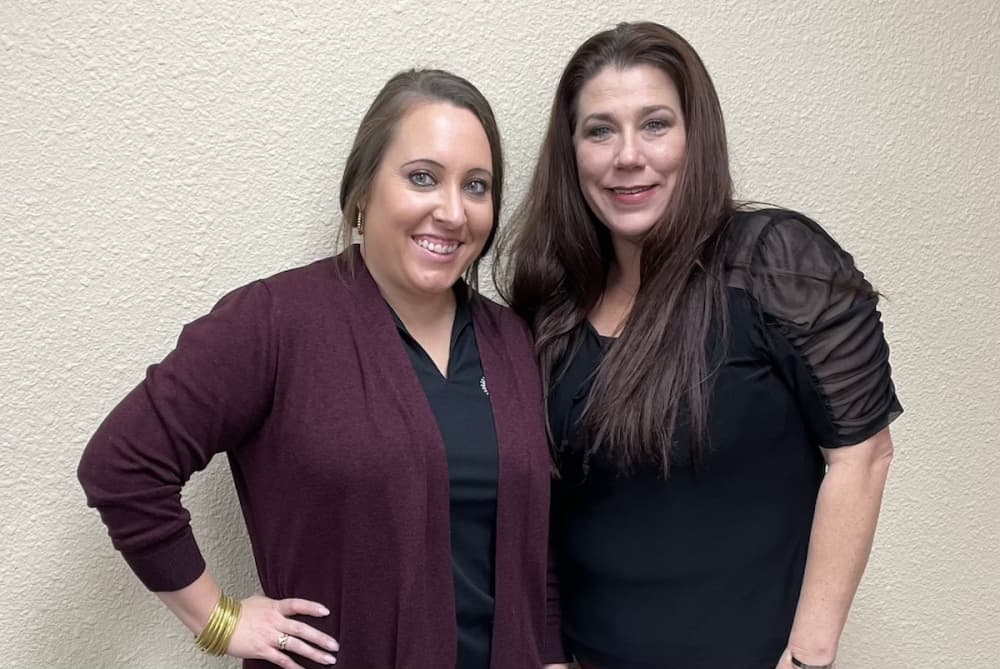 Two women pose for a photo.