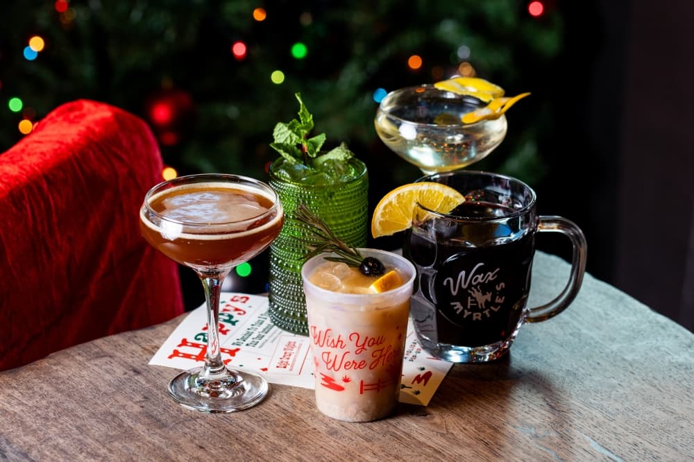 A table with Christmas decorations holds several themed drinks.