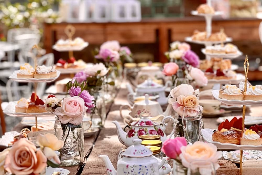 Tea party with tea cups and roses displayed on table