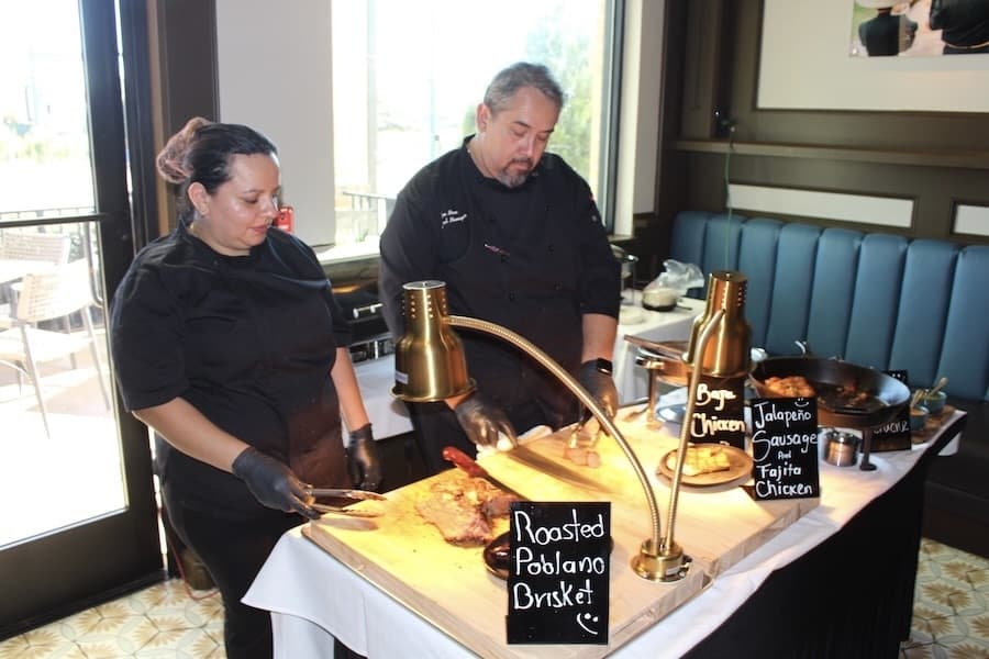 Raquel Privado (left) and Mattito's General Manger Alex Mora cut some meat and chicken dishes at the Sunday buffet at Mattito's. (Don Munsch/Community)
