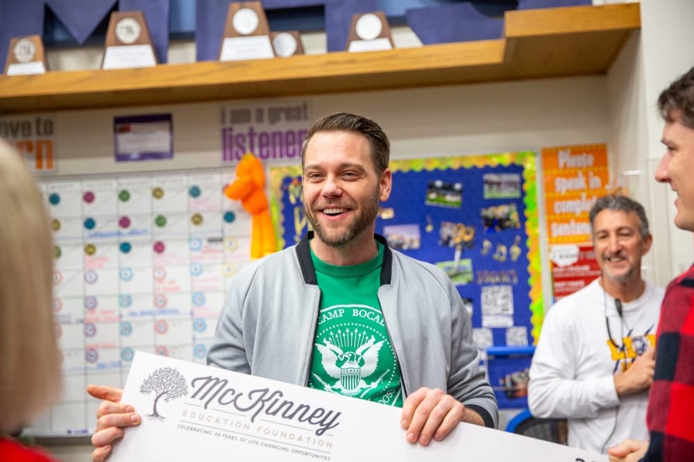 a man smiles after receiving an award