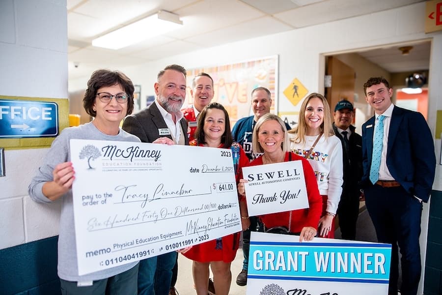 A group of people pose with a large cheque