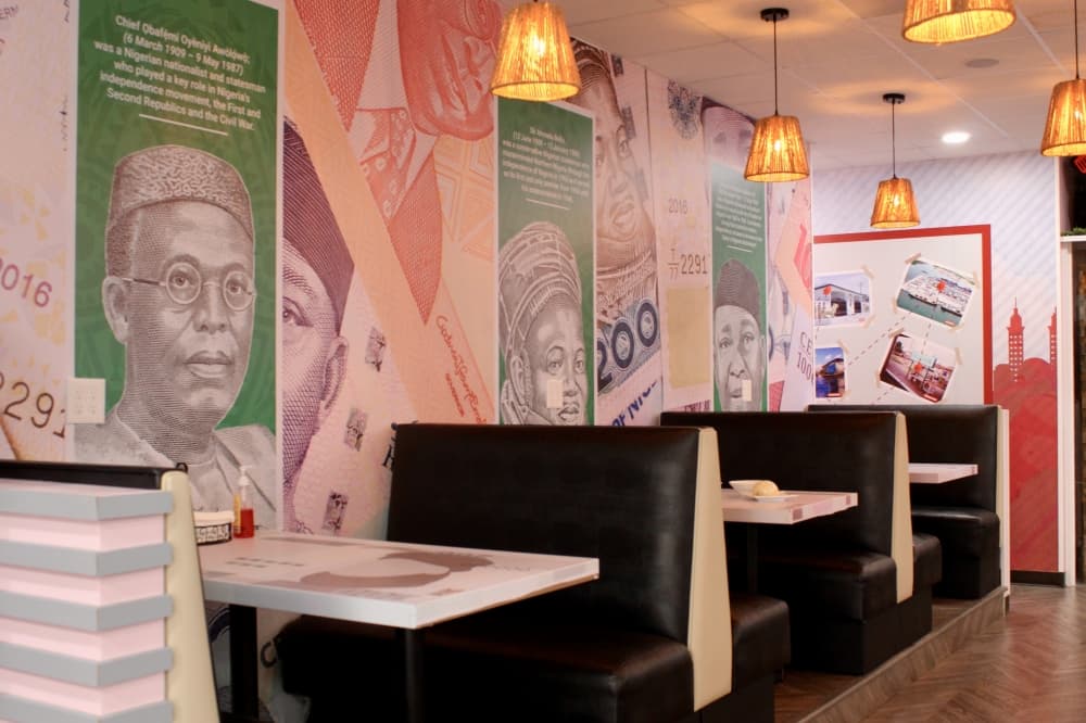Restaraunt indoor dining area with tables and African history showcased on the walls