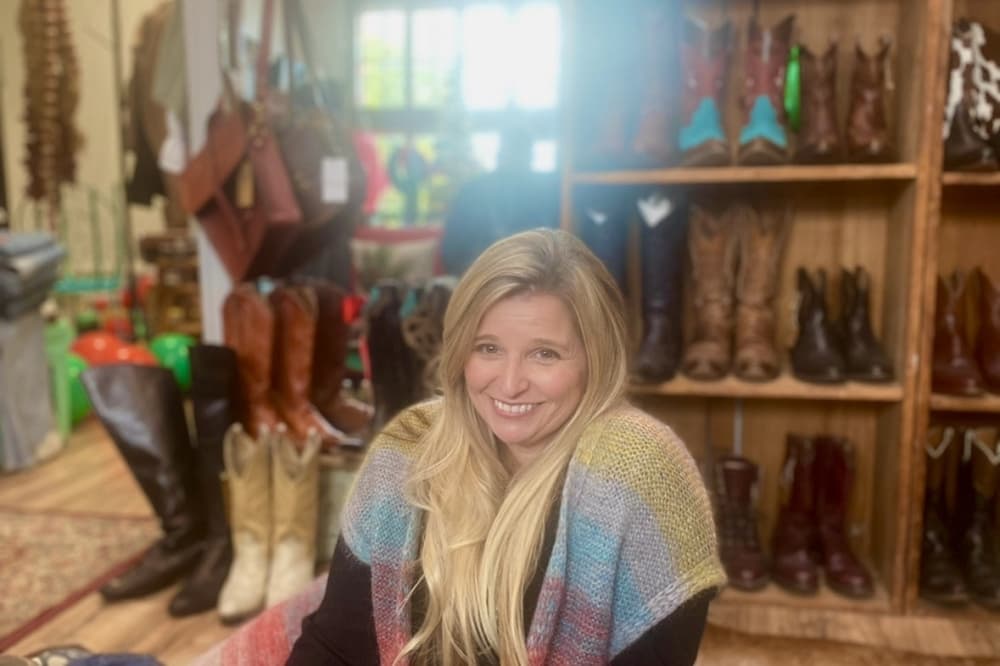 owner posing on the floor with boots in the background