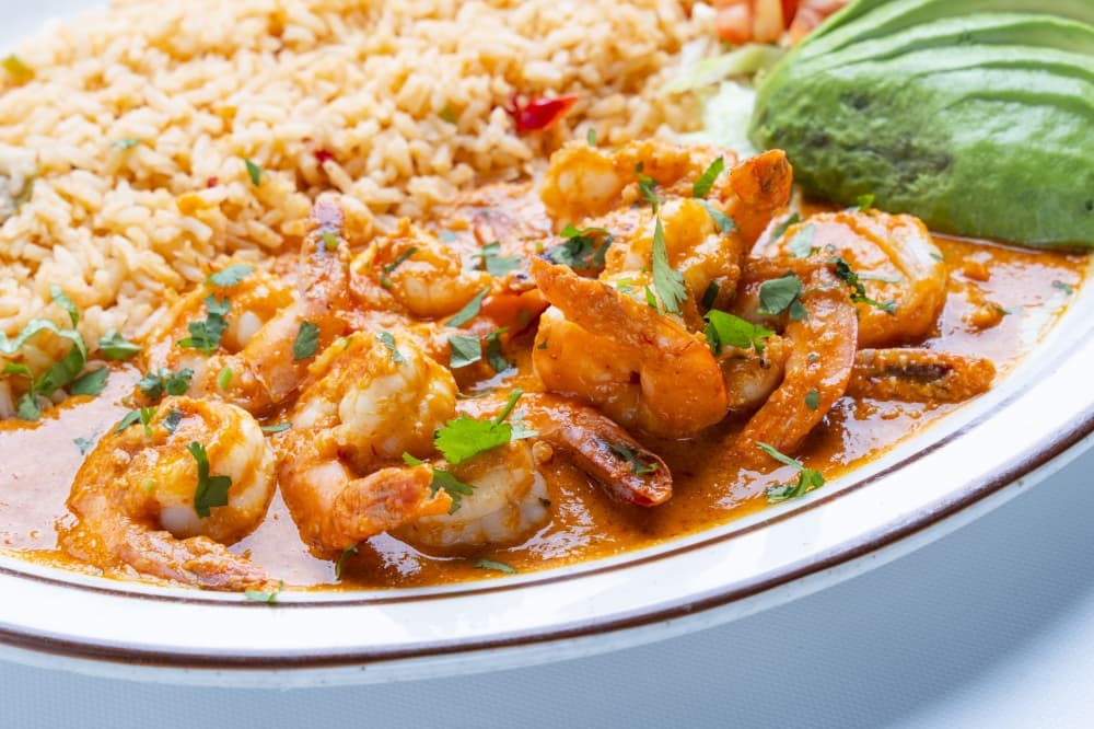 shrimp with rice and avocado slices on the side