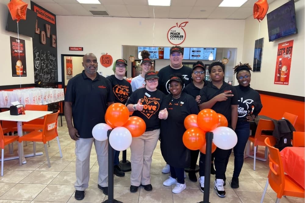 Owner Troy Barber stands with wife, son and staff at the opening of Peach Cobbler Factory. (Courtesy Troy Baker)