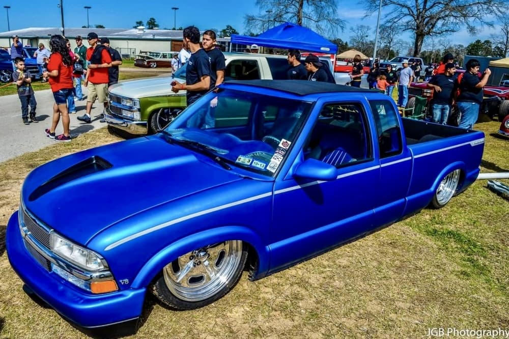 Blue truck at car show with people in the background