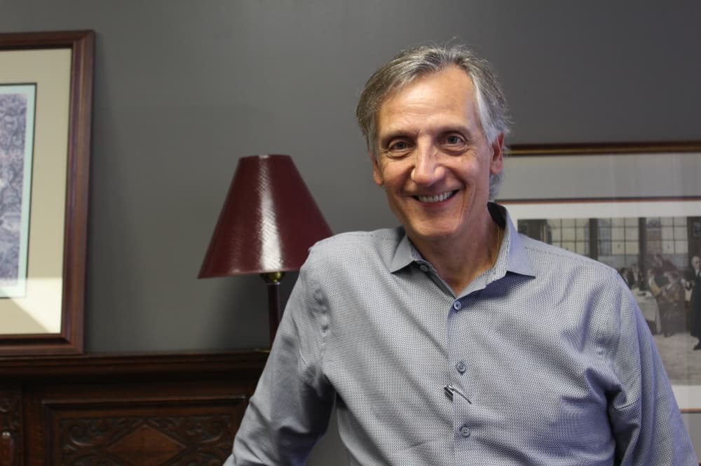 An image of Bellaire Mayor Gus Pappas, sitting as a lamp and two picture frames stand behind him. 