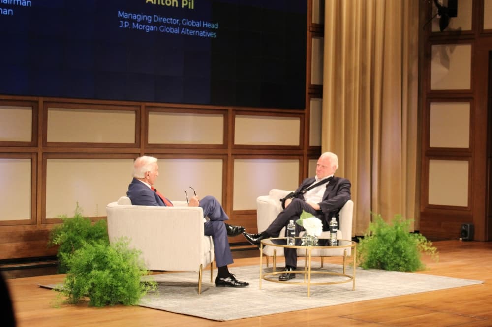 Executive Chairman Herbert Weitzman and Anton Phil, global head of alternatives at J.P. Morgan, speak to each other while seated in two chairs on a stage. 