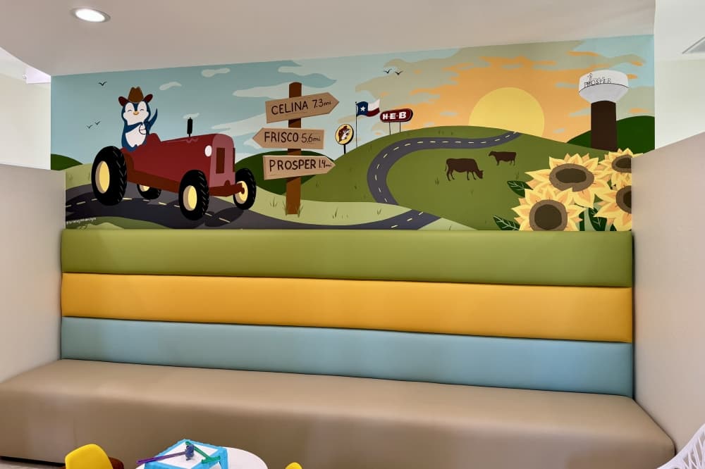 a mural of a penguin wearing a cowboy hat and blue bandana driving a tractor