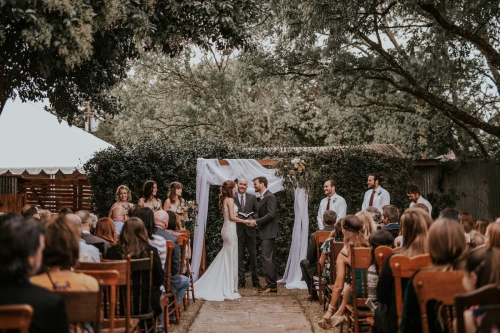 Natalie and Ryan Roberts stand holding hands at the altar before getting married. (Courtesy Chelsey Medina)