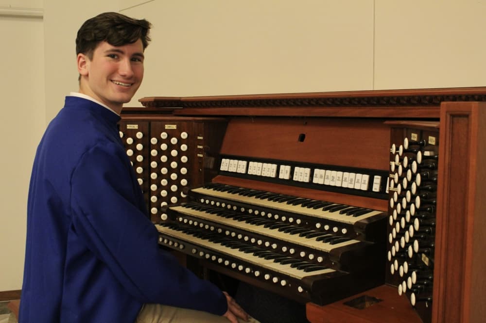 Student sitting at a pipe organ console
