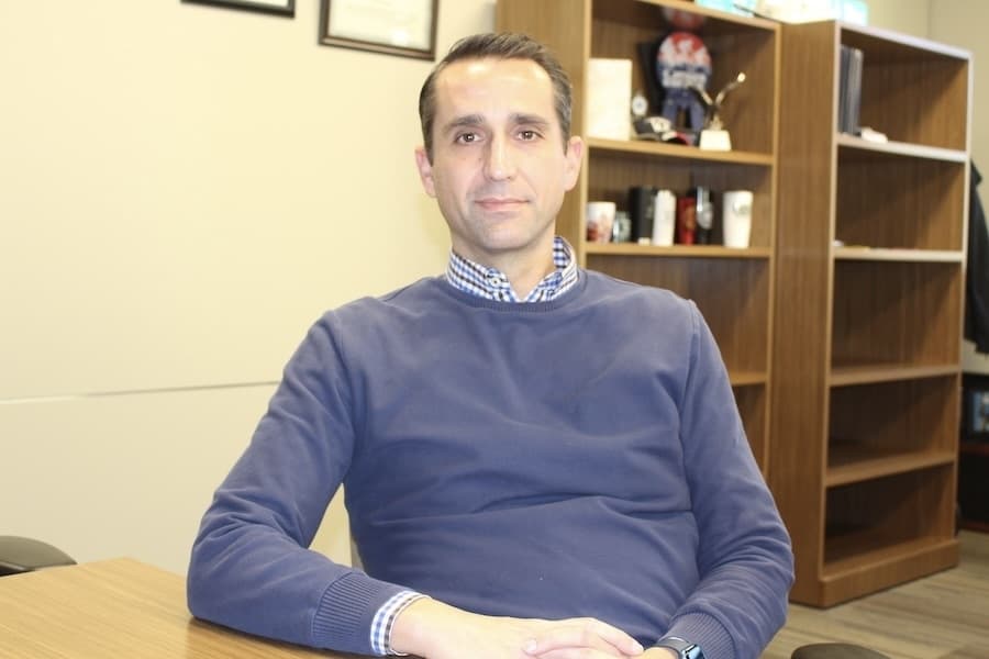 Picture of a man sitting in a table in an office.