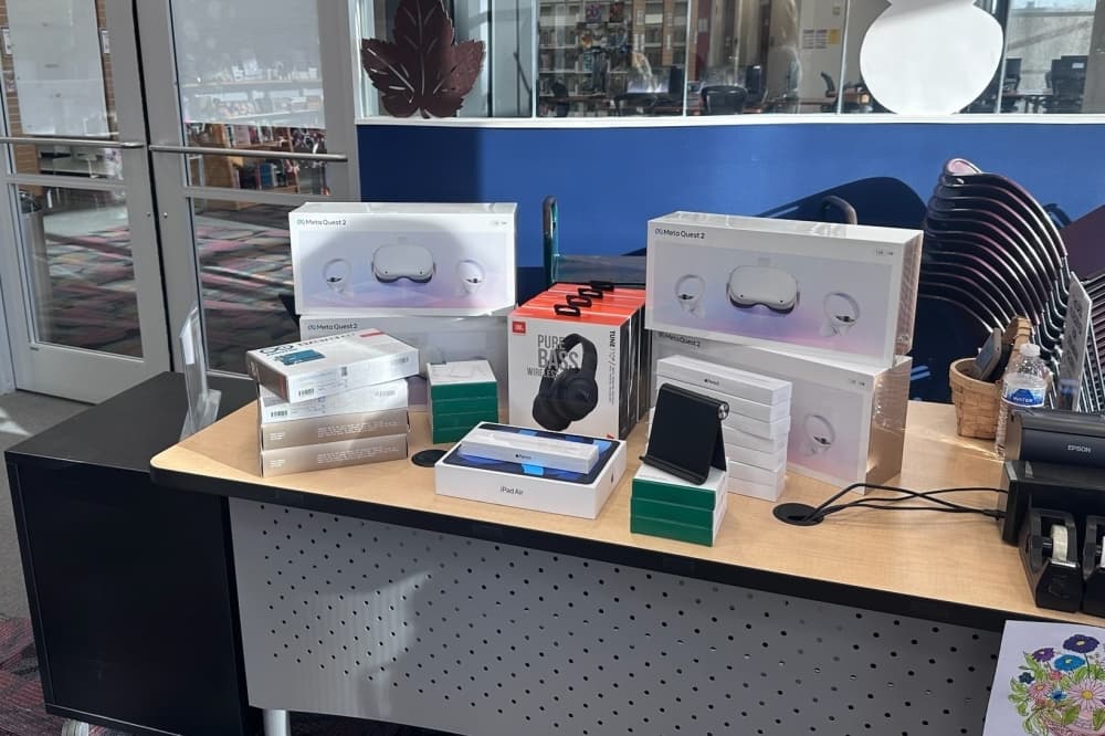 Technology such as iPads and headphones sits on a desk in the library's renovated teen space