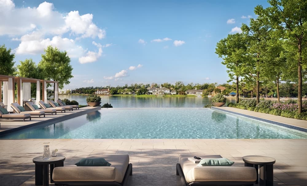 A swimming pool at the side of a lake at a residential complex