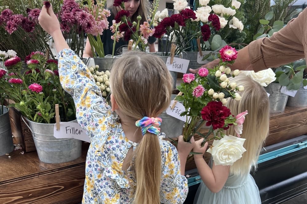 Two children choose flowers from the truck for their bouquets.