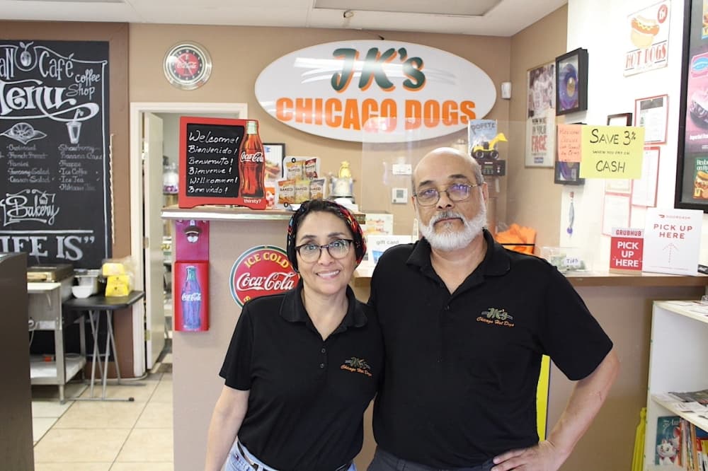 two people stand in a hot dog restaurant