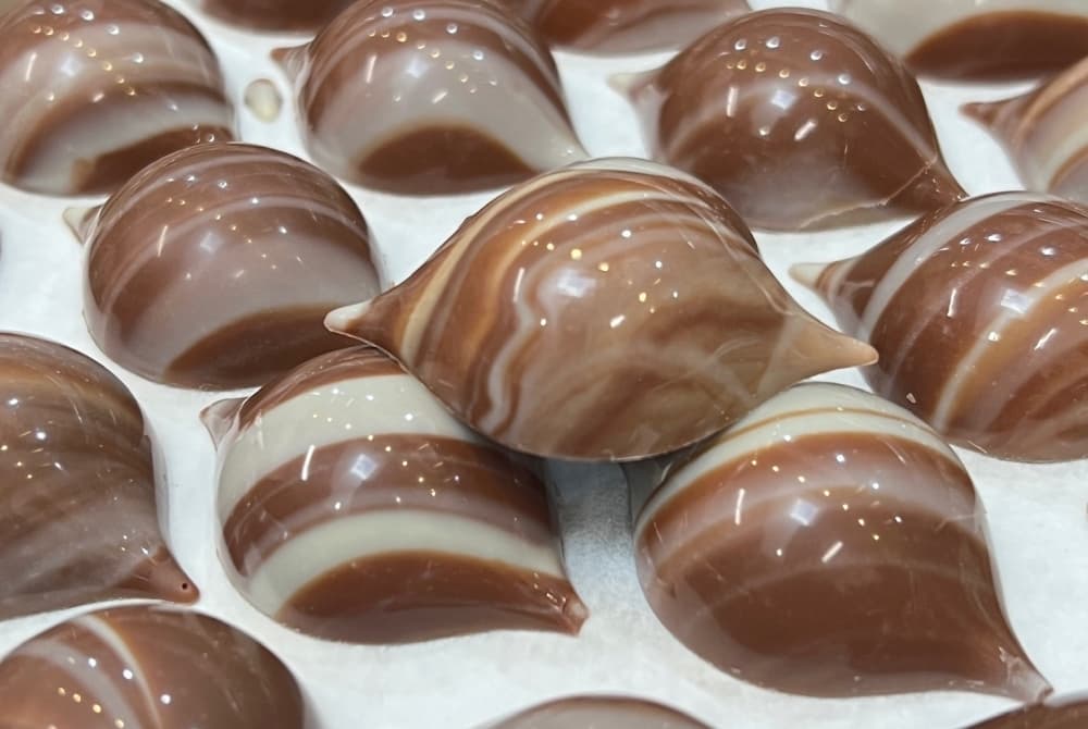 Brown and white swirled chocolate bonbons are shown.