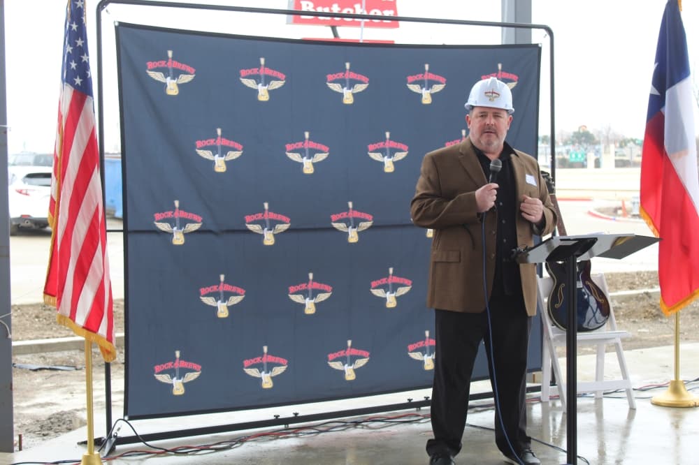 Dave Stevens speaks in front of Rock & Brews background