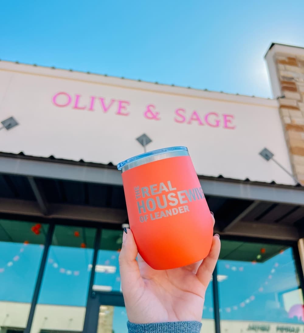 Orange tumbler in front of store sign