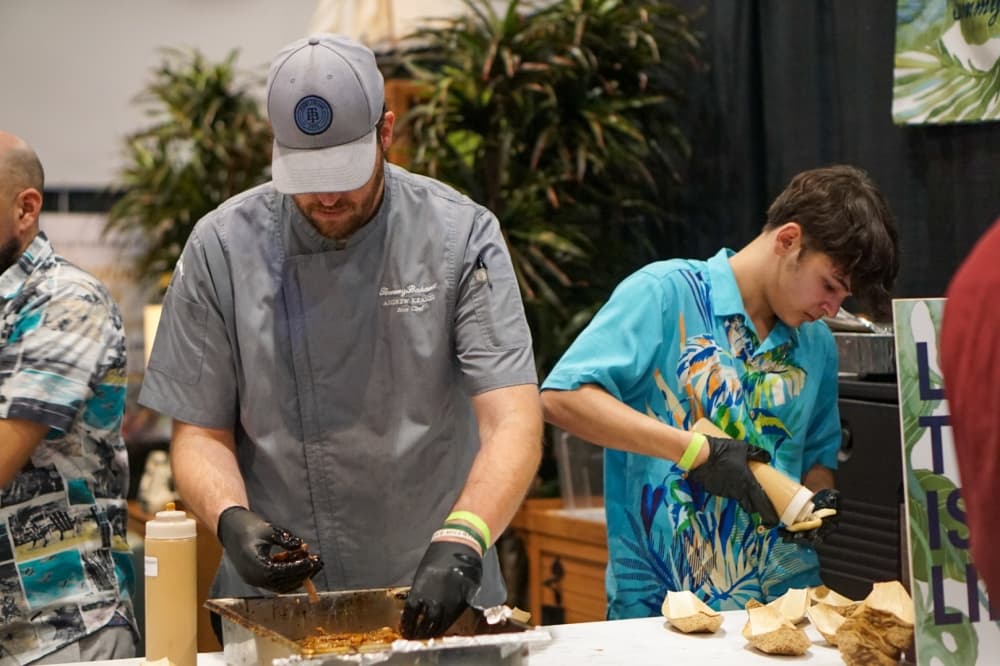 Two men work on making appetizers