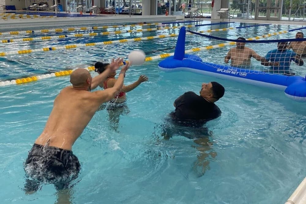Operation Comfort members playing pool volleyball. 