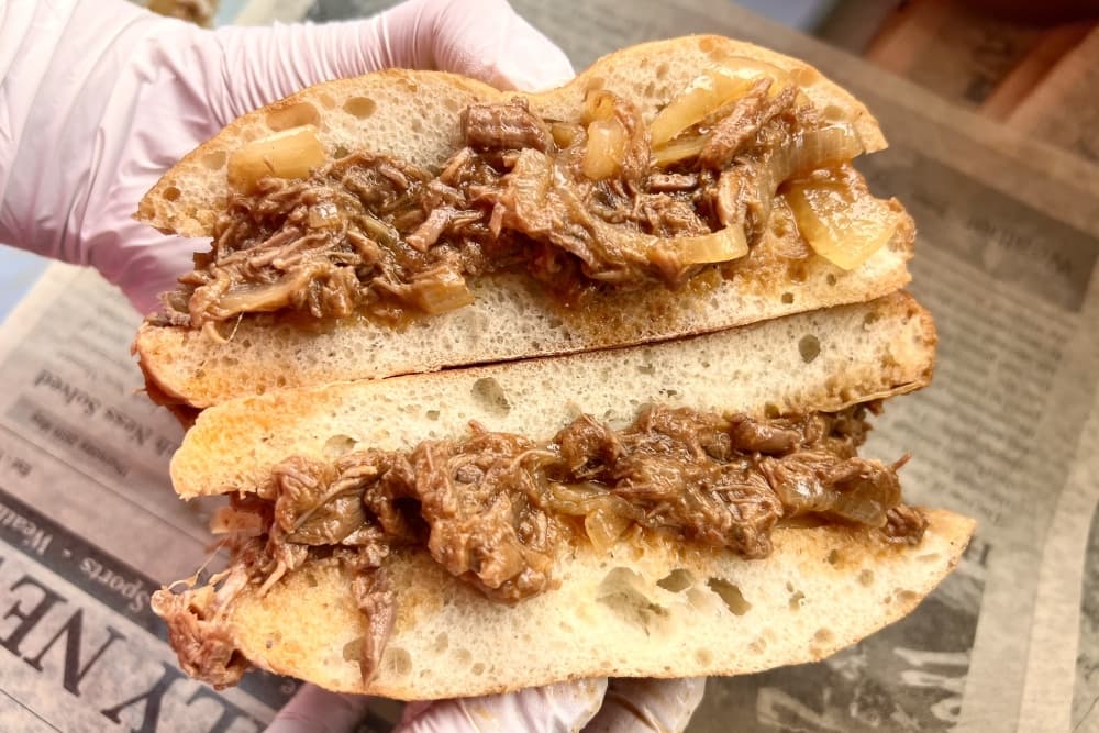 A brisket sandwich is shown split in half.