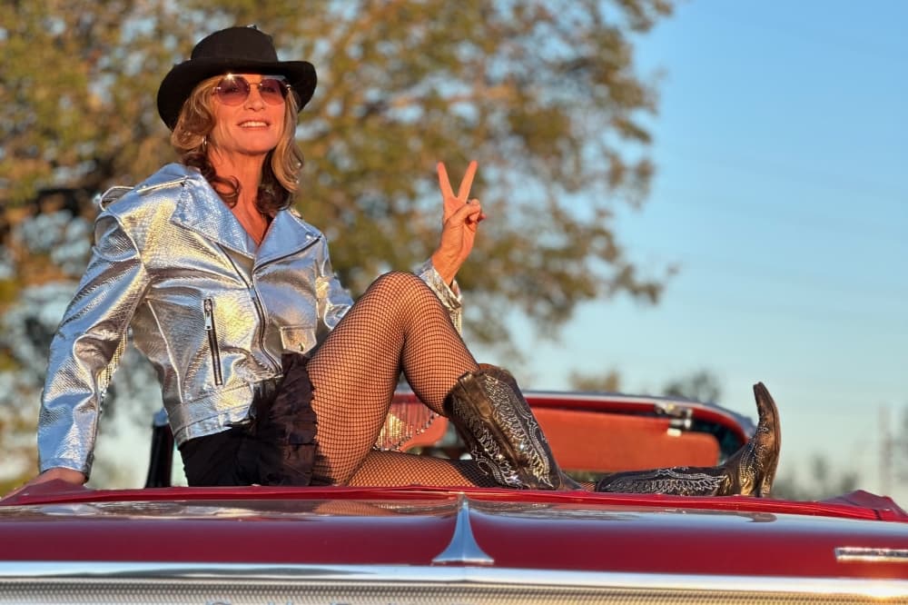 woman posing while sitting on the back of a convertible