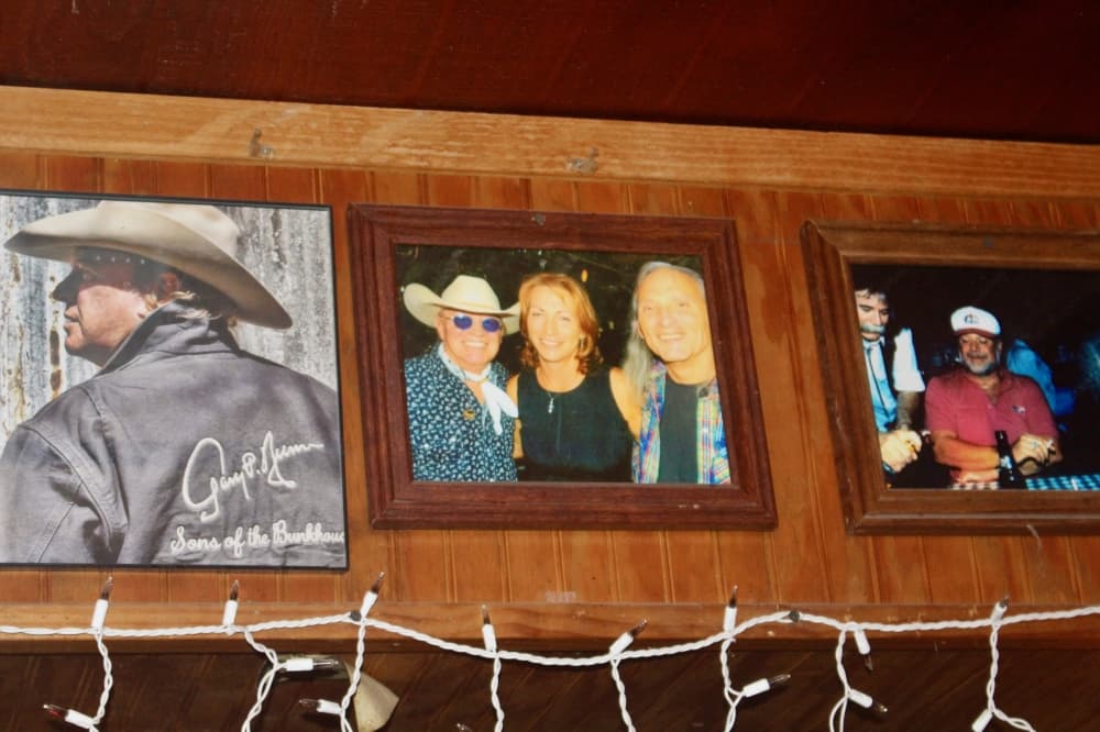 framed photos on a wood-paneled wall