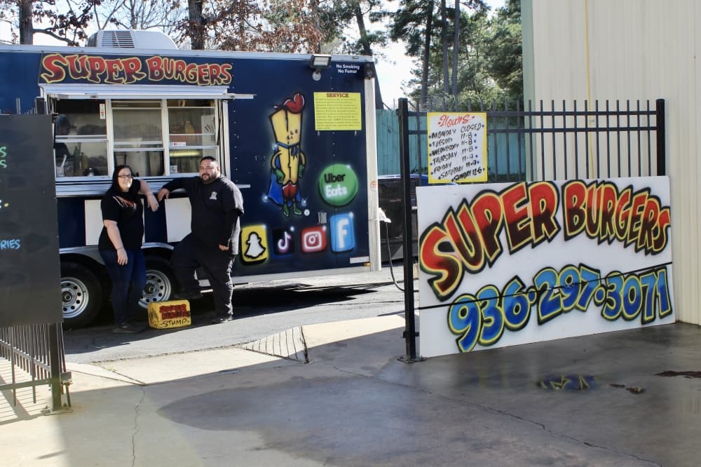 Two restaurant owners standing in front of their food truck