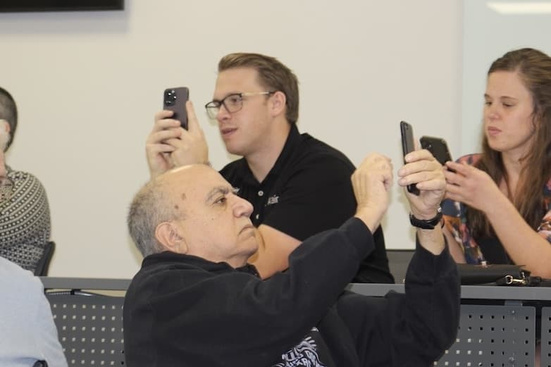 Picture of people trying to send messages on their phones.