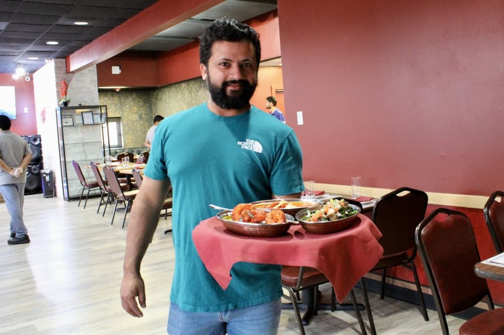 Deepak Bhandari serving tray of food
