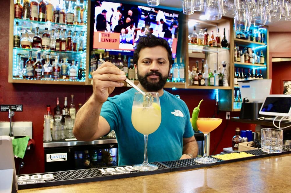 Restaurant owner Deepak Bhandari at bar making a drink